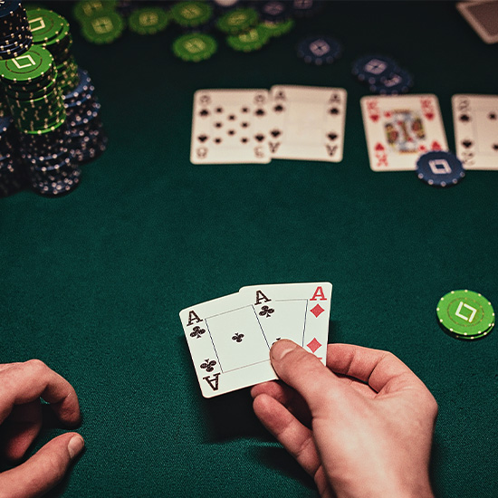 Player hand holding a pair of aces